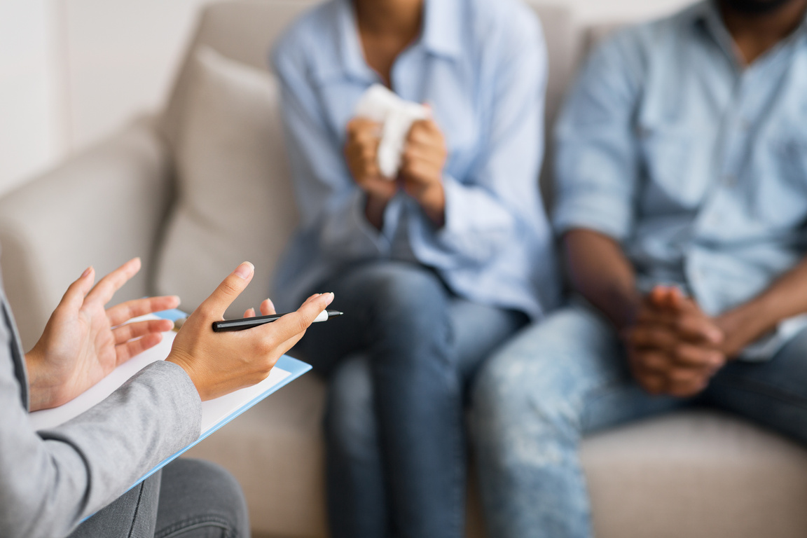 Psychologist counselling young african american married couple